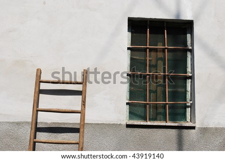 Old wooden stair against the wall of a old house with a window on the right