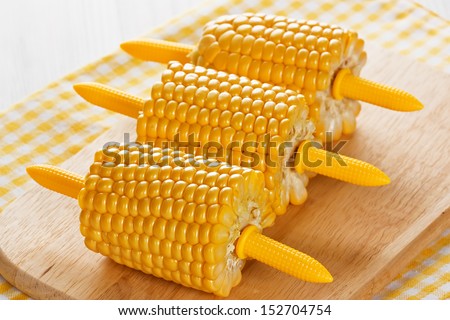 Ripe cobs of sweet corn on wooden background