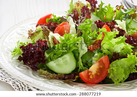 Fresh salad with green, red lettuce, tomato and cucumber