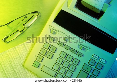 Finance Concept: day trader. Adding machine on newspaper business section.