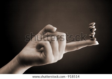 Accounting Concept: Bean Counter: Woman's hand with a stack of beans balancing on the finger tip.