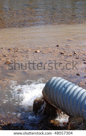 sewer pipe draining water, polluting shallow river