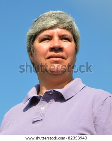 Older woman looking forward, sky in background