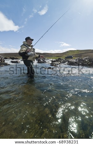 Fly fisherman casting the fly in beautiful surroundings in Iceland