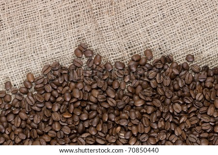 Background image of many coffee beans spilled out on a canvas material