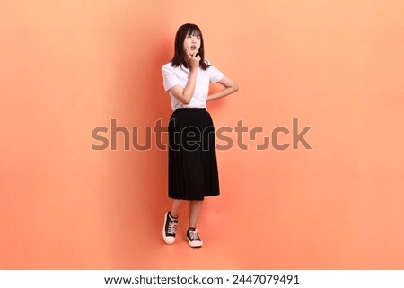 Image, Stock Photo teenager in uniform wonders about the sharpness of the sickle she is holding in her hand … and at the same time is a little worried she might hurt herself