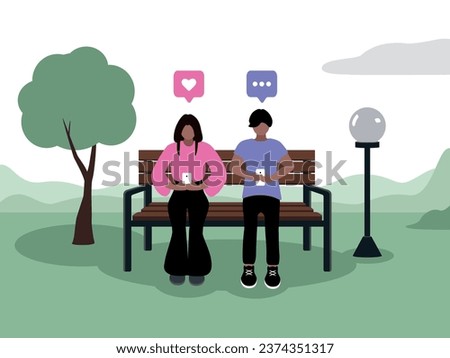 A couple of young people with dark skin, dark hair of Caucasian appearance in fashionable clothes are sitting on smartphones in a park on a bench next to a tree and a lantern. The girl puts a like