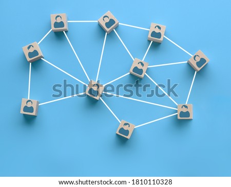 Wooden blocks with people icon interconnected by white lines on blue background. Cooperation, teamwork, business training concept. Social connections, joining to solve tasks Foto stock © 