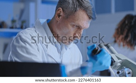 Similar – Image, Stock Photo Serious chemist examining liquid in flask in lab