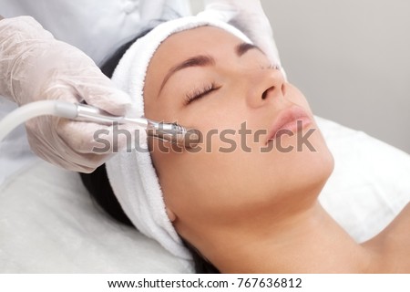 The cosmetologist makes the procedure Microdermabrasion of the facial skin of a beautiful, young woman in a beauty salon.Cosmetology and professional skin care. Foto stock © 