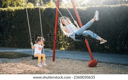 Similar – Image, Stock Photo Father and mother swinging their baby sitting on the green grass in the park. Infant is laughing happy.