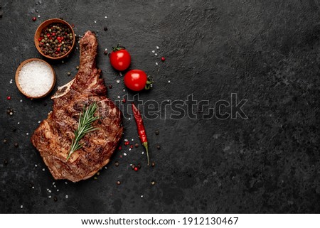 grilled cowboy steak with spices  on a stone background with copy space for your text