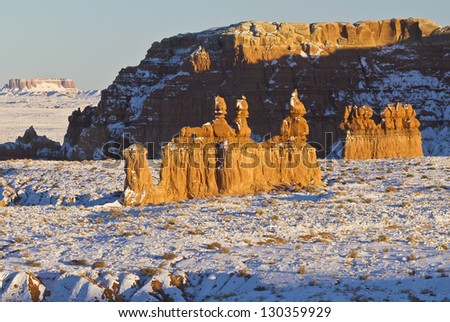 Late afternoon sun hits a snow-covered iconic rock formation in Goblin Valley State Park, Utah