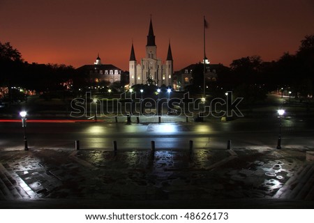 Tail lights on Decatur street in front of Jackson Square silhouetted by the lights of Bourbon Street in the French Quarter of New Orleans, LA