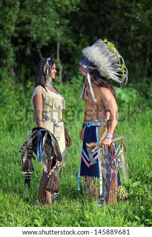 Indian chief with a young Indian on the green meadow