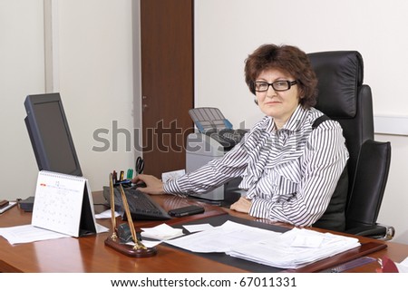 The adult woman the chief works at office behind a table