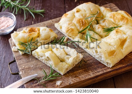 Similar – Image, Stock Photo Homemade Italian Focaccia, with tomato and olive oil on a rustic wooden background.