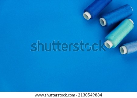 Blue thread. A set of spools of sewing thread. Several spools of thread in different shades of blue on a blue background. place for text Foto stock © 