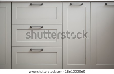 White kitchen cabinets with metal pulls or knobs on the doors close up. Foto d'archivio © 