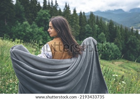 Similar – Image, Stock Photo Female traveler with blanket standing on lake shore against mountains