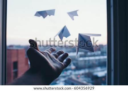 A man's hand lets go little paper planes out of window to nowhere Stock fotó © 