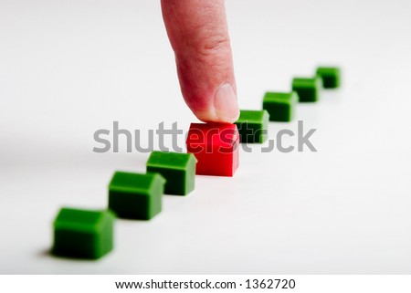 finger pointing red house, real estate concept
