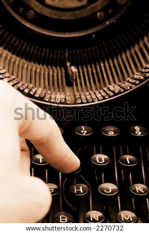 Closeup of finger and signs on old typewriter in warm colors