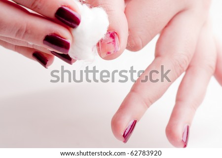 manicure process: removing nail polish with nail-polish remover and cotton wool