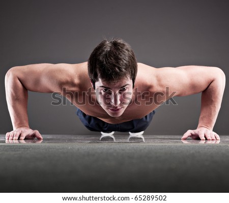 Muscular man doing push-up, studio shot