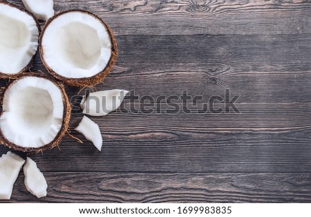 coconut halves, coconut pieces on a wooden background top view. background with split coconuts close-up. coconuts and copy space. coconuts lay flat.