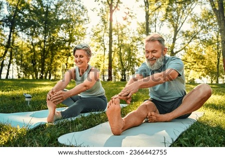 Similar – Image, Stock Photo Focused couple doing yoga in Awkward pose in park