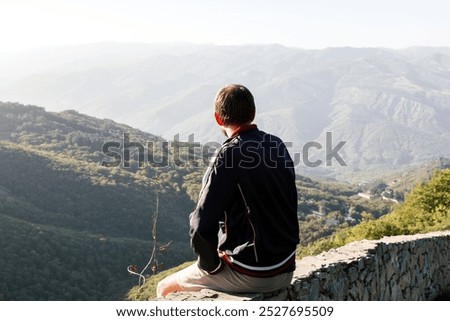 Similar – Image, Stock Photo Anonymous traveler admiring landscape of volcano under cloudy sky