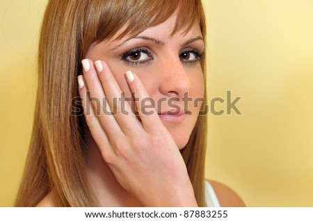 beautiful young woman with hand on a face