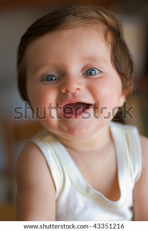 happy smiling six-month-old toothless child with blue eyes