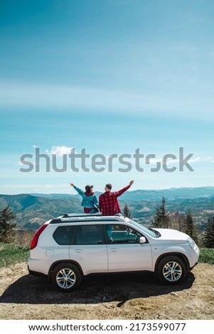young woman sitting on the top of the suv car at mountain peak enjoying the landscape view at summer sunny day Photo stock © 