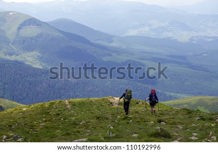 man and woman walking in the mountains