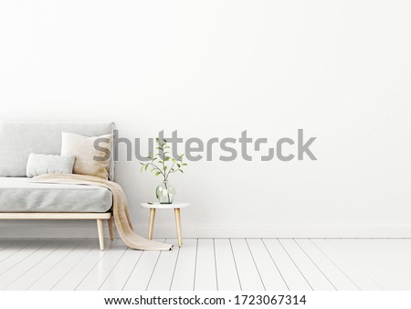 Interior wall mockup with empty white wall, gray sofa, beige pillows and green plant in vase. Free space on right.  3D rendering, illustration.