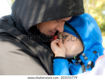 Dad hugging his sad son. Outdoor