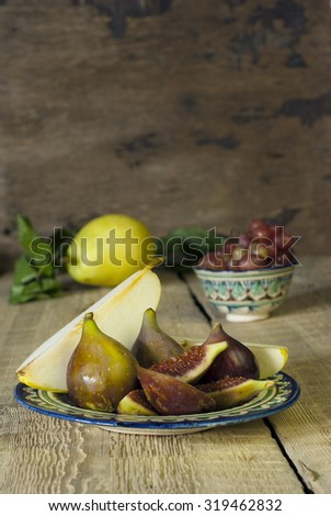 figs and pear on a plate and on rustic  wooden table