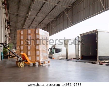 Cargo shipment loading for truck. 
Warehousing logistics and transportation, hand pallet truck with cargo pallet shipment, trucks docking load cargo at warehouse. ストックフォト © 