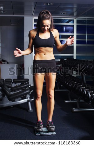 Beautiful young woman working out in fitness club