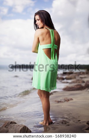 The nice woman in the green dress on the beach