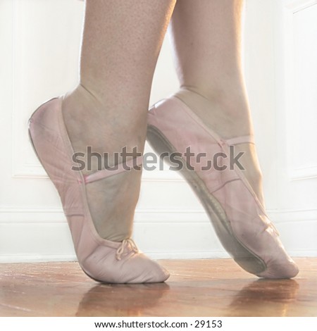 Ballet feet in Releve on a hardwood dance floor