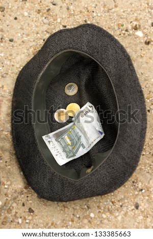 Old hat of beggar with cash money