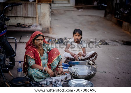 JAISALMER, INDIA - MARCH 22 : Indian woman with her child posing in the street on March 22, 2014 in Jaisalmer, India