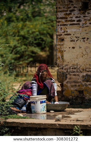 BIKANER - MARCH 22 : woman washing clothes in the street on March 22 , 2013 in Bikaner,India