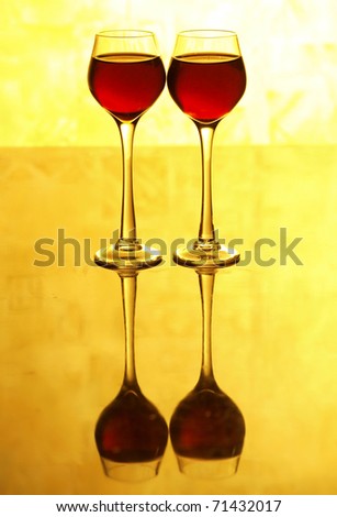 Color photo of a glass of red wine glasses on yellow background