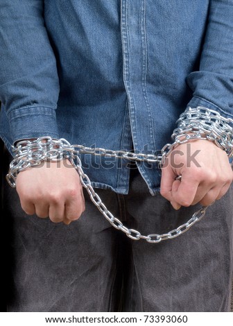 Color photo of a prisoner with a chain on his hands