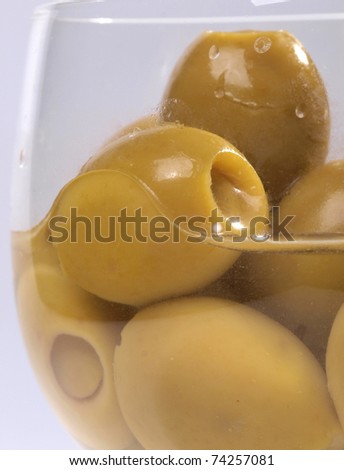 Color photo of green olives in a glass