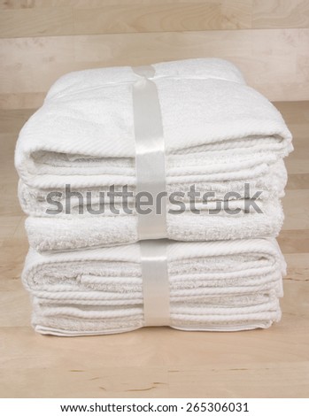 A pile of clean fresh towels on a wooden floor